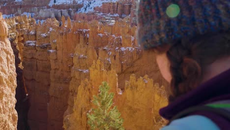 Girl-woman-hiking-with-red-rocks-formation-and-snow-near-Bryce-Canyon-in-southern-Utah