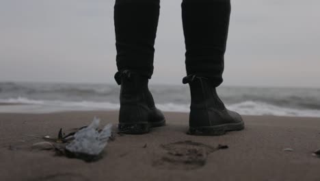 A-Man-Standing-By-The-Shore-Wearing-Black-Shoes-With-Soft-Waves-Touching-HIs-Sole---Close-Up-Shot