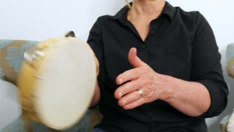 Close-up-view-of-a-woman-playing-a-Tambourine,-tapping-rhythm