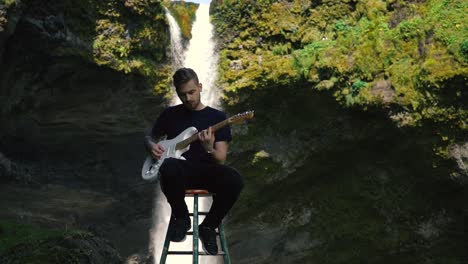 Mann-Spielt-Gitarre-Vor-Einem-Wunderschönen-Wasserfall-In-Island-11