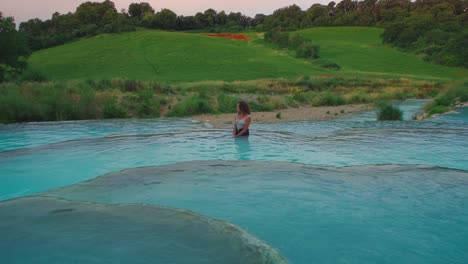 4K-UHD-Cinemagraph---seamless-video-loop-of-a-young-woman-relaxing-in-thermal-hot-springs-basin-in-Saturnia,-Italy