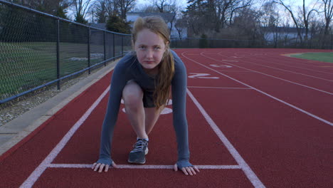 A-teen-girl-in-the-ready-position-on-a-running-track