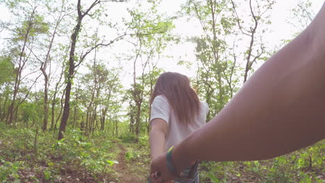 Couple-holding-hands-and-walking-in-forest