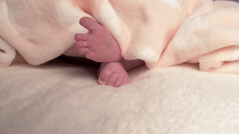 Beautiful-Baby-newborn-is-lying-in-bed-and-shows-hands-and-feet,-mother-fandles-with-baby-and-covers-her-up-with-a-cosy-coverlet,4k-60p-Apple-ProRes422,-with-external-Atoms-recorder