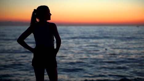 A-Silhouette-Of-A-Young-Sexy-Lady-Standing-At-The-Shore-With-The-Majestic-Sundown-On-Her-Background---Medium-Shot
