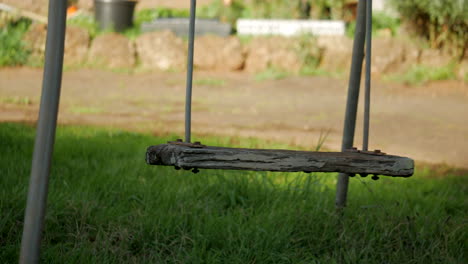Empty-metal-swing-with-rotted-wooden-seat