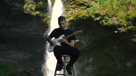 Man-playing-guitar-in-front-of-a-beautiful-waterfall-in-Iceland-15