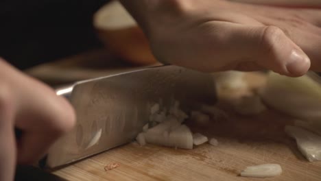Mincing-Onions-Using-A-Sharp-Knife-Into-A-Wooden-Board