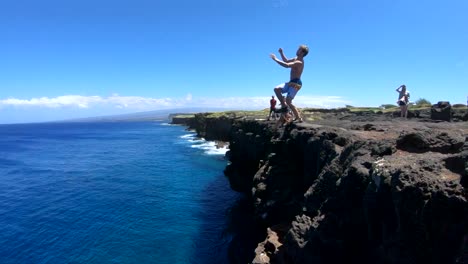 Slow-Motion-shot-of-a-man-doing-a-gainer-off-of-a-cliff-at-South-Point,-Big-Island,-Hawaii