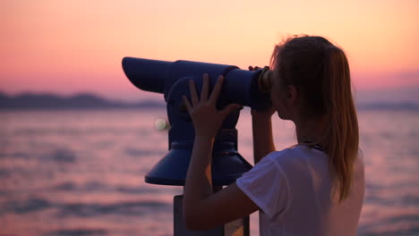 A-Beautiful-Young-Woman-Looking-At-The-Sky-With-A-Metal-Telescope-At-The-Coast-During-Sunset---Close-Up-Shot