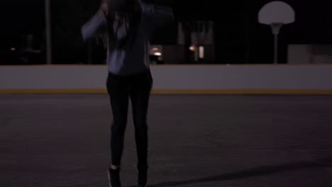 Slow-motion-jump-shot-at-outdoor-court-at-night,-teenage-girl-with-brown-hair