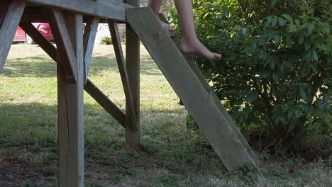 Child-carefully-steps-down-small-ladder-from-play-structure