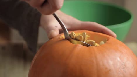 Removing-pumpkin-seeds-from-a-ripe-fresh-pumpkin-with-a-spoon