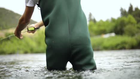 Shot-of-a-male-fisherman-wearing-waders-while-Fly-Fishing
