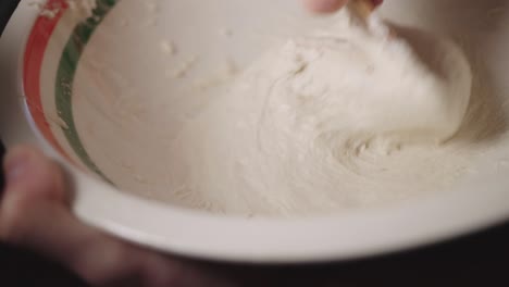 Hand-Mixing-A-Sticky-Flour-On-A-Bowl-With-A-Spoon---Closeup-Shot