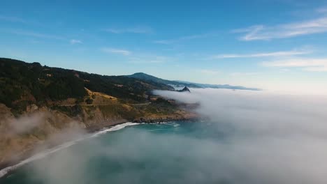 AERIAL:-High-above-a-foggy-Oregon-ocean,-our-drone-pushes-towards-the-coastline