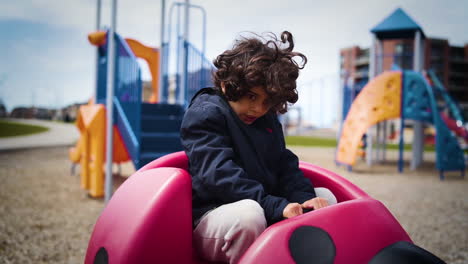 Young-boy-getting-dizzy-in-a-playground-at-a-neighbourhood-park