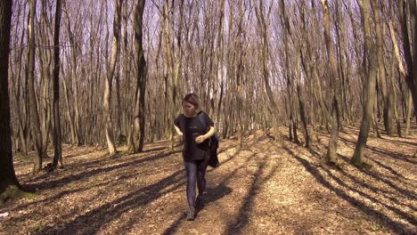 A-young-blond-woman-alone-in-the-woods-organizes-her-day-pack