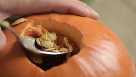 Removing-seeds-from-a-ripe-fresh-pumpkin-with-a-spoon