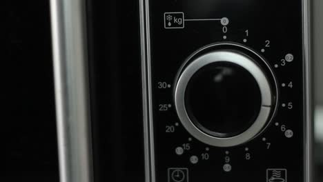 Setting-microwave-timer-to-five-minutes-and-turning-microwave-of---close-up-shot---front-view