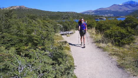 Young-woman-walking-on-a-trail-and-waving-with-hands-in-Patagonia,-Argentina