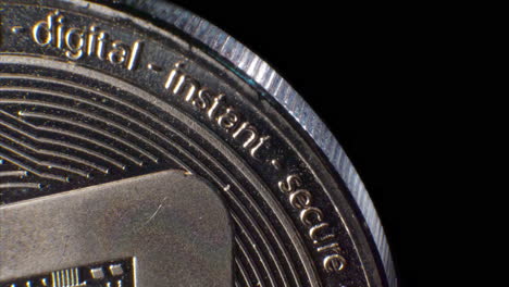 Close-up-looping-shot-of-a-silver-digital-decentralized-cryptocurrency-coin-with-the-words-instant-and-secure-with-copy-space-for-titles-and-backgrounds