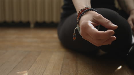 Slider-shot-of-a-woman's-hand-in-a-meditative-prayer-gesture-for-yoga-in-4K-UHD