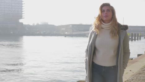 Happy-young-tourist-woman-explores-a-city-along-the-pier