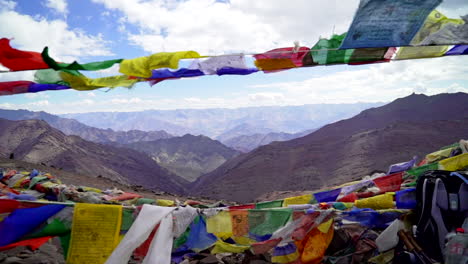 Viewpoint-in-the-Himalayan-mountains-with-Tibetan-prayer-flags-in-the-wind,-push-in-a-handheld-shot-towards-the-scenery
