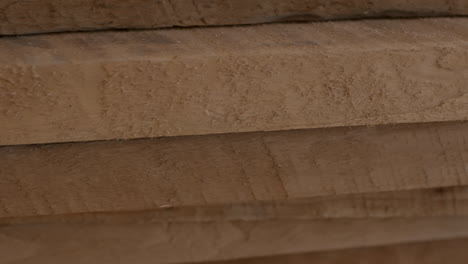 A-stack-of-fresh-cut-lumber-boards-in-close-up-showing-texture-tracking-left