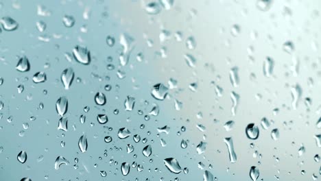 Regentropfen-Laufen-Das-Glas-Auf-Einem-Schönen,-Unscharfen-Hintergrund-In-Nahaufnahmemakro-Hinunter