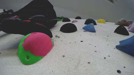 Close-up-of-an-indoor-climbing-gym-wall-full-of-different-colour-holds-seen-from-below-1
