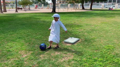 Arabischer-Emiratischer-Junge,-Der-Fußball-Spielt-Und-Kandura-Dish-Dash-Trägt
