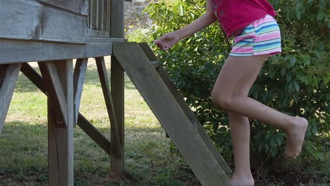 Young-girl-in-pink-shirt-climbs-ladder-on-wooden-playground-toy