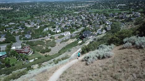Drone-Shot-following-an-active-man-running-on-the-outdoor-mountain-trails-above-Draper-City,-Utah-2