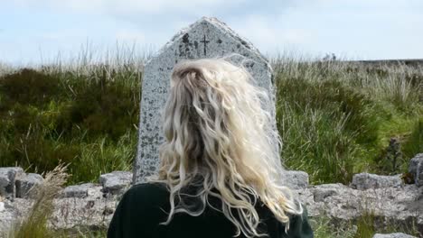 Back-of-Blond-Girl�s-Head-Staring-at-an-Old-Tumb-Stone