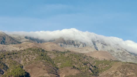 Lapso-De-Tiempo-De-Nubes-Ondulantes-Rodando-Sobre-La-Cima-De-Una-Montaña