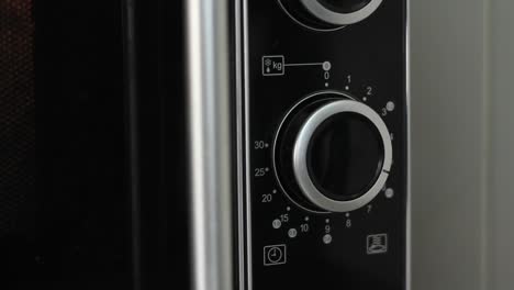 Setting-microwave-timer-to-six-minutes-and-turning-microwave-off---close-angled-shot