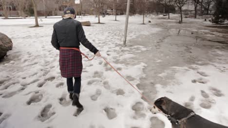 Eine-Person-Und-Ihr-Hund,-Die-Durch-Schnee-Und-Matsch-Laufen