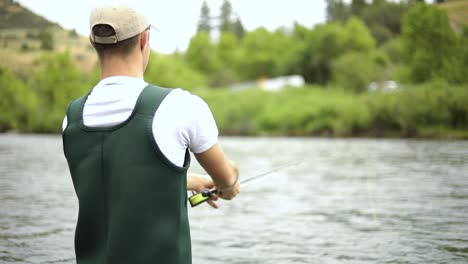 Shot-of-a-Caucasian-male-fisherman-casting-his-hook-while-Fly-Fishing-2