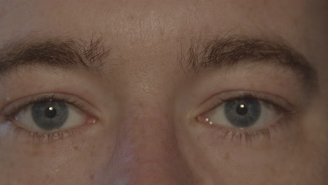 Paar-Blaue-Männliche-Augen,-Die-In-Die-Kamera-Starren-Und-Langsam-Blinzeln
