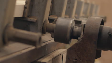 Industrial-machine-tightens-bolts-in-a-workshop,-close-up-in-slow-motion