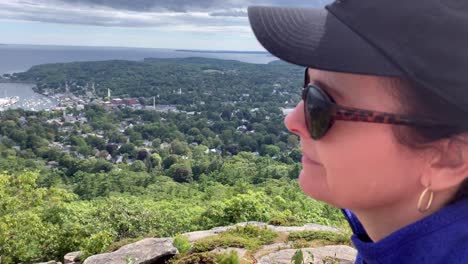 4K-Lady-gazes-down-on-Camden-Maine-from-atop-Mount-Battie-outside-of-Camden-Maine