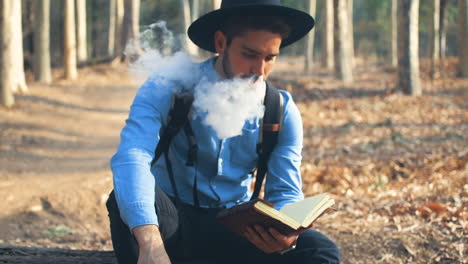 Explorer-vaping-and-reading-in-the-woods