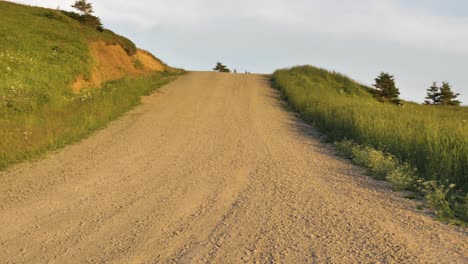 A-quiet-dirt-road-crosses-a-green-hillside-in-the-Magdalen-Islands