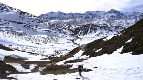 Frau-Beim-Trekking-Und-Klettern-Auf-Einem-Schneebedeckten-Hügel