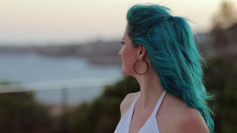At-one-with-nature---attractive-blue-hair-woman,-shallow-DOF,-ocean-behind,-copy-space