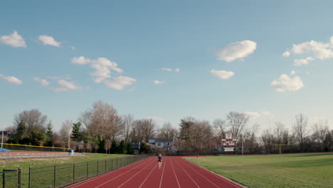 Aerial-of-teen-girl-warming-up-on-a-high-school-track