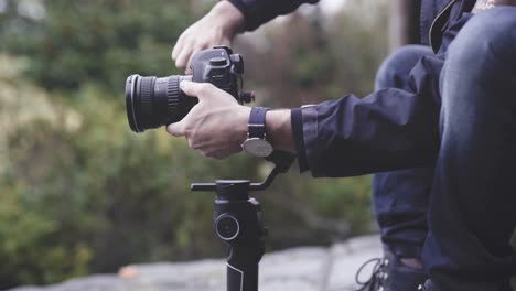 Cameraman-stabilizing-camera-on-gimbal,-close-up-shot
