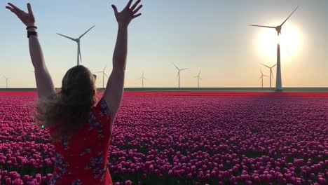 Girl-in-field-of-tulips-and-wind-turbines-throwing-flowers-in-air